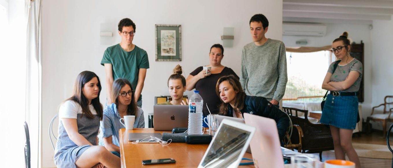 Group of young professionals engaged in a collaborative meeting in a modern office setting.