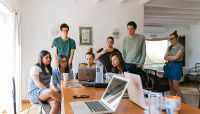 Group of young professionals engaged in a collaborative meeting in a modern office setting.
