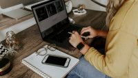 person in blue denim jeans using macbook pro