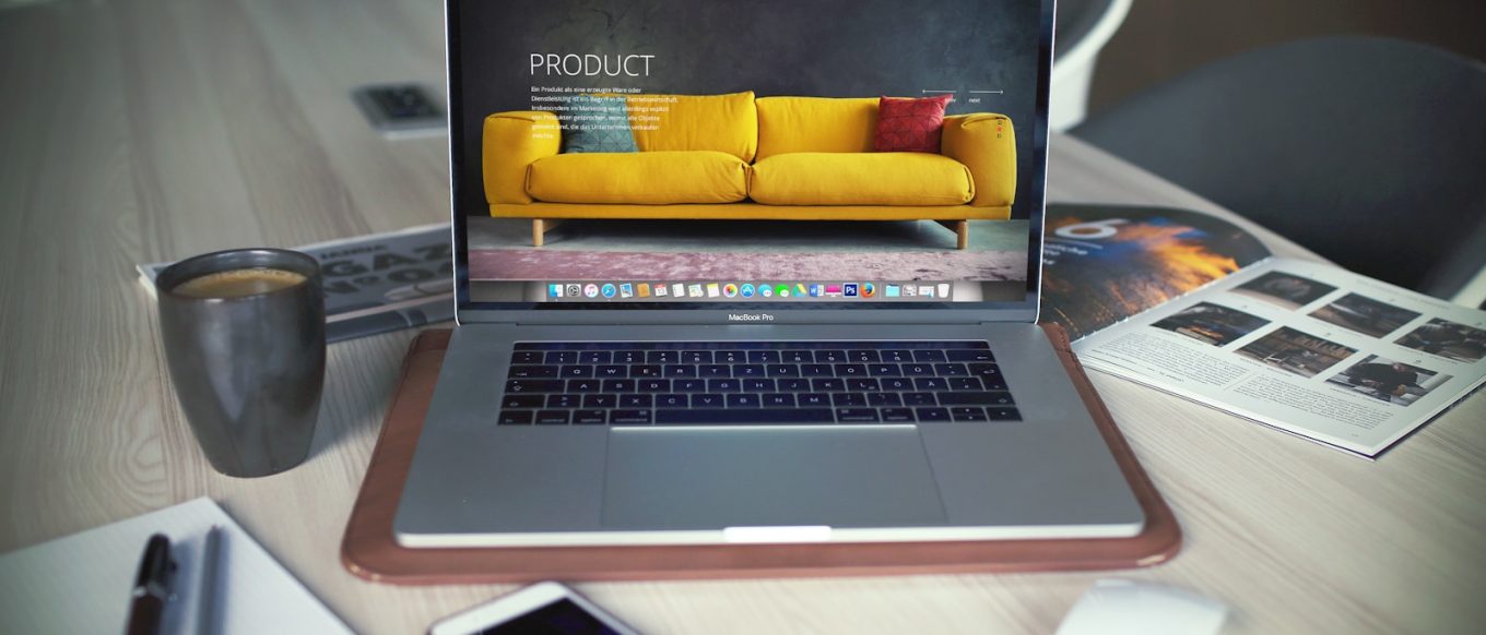 turned on MacBook Pro beside gray mug
