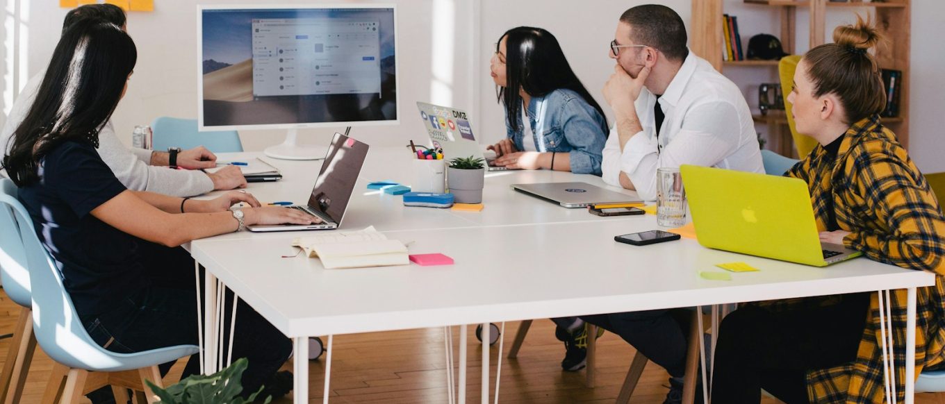 five person by table watching turned on white iMac